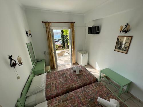 a bedroom with a bed and a table and a window at Asterias Hotel - Seafront in Parikia