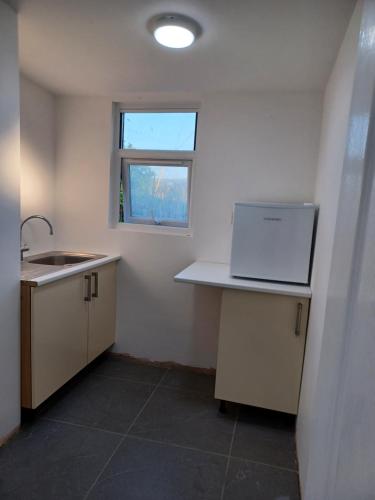 a kitchen with a sink and a laptop on a counter at Yr Wyddfa Bell Tent - Pen Cefn Farm, Abergele, Conwy in Abergele