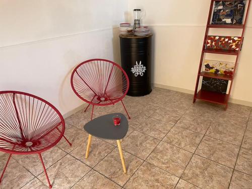 2 chaises rouges et une table dans une pièce dans l'établissement U riposu, à Bastia