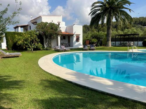 a swimming pool in front of a house at Authentic Villa with amazing pool in Santa Gertrudis de Fruitera
