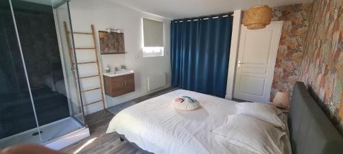 een slaapkamer met een wit bed en een badkamer bij L'Ecrin des Alpilles in Graveson
