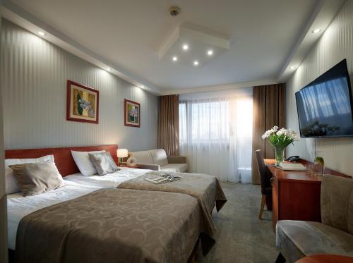 ein Hotelzimmer mit einem Bett und einem Schreibtisch in der Unterkunft Arka Medical Spa in Kołobrzeg