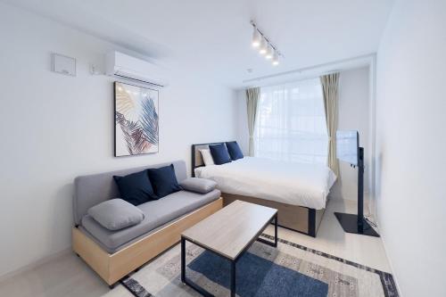 um pequeno quarto com uma cama e um sofá em toggle BUNKYO KORAKUEN em Tóquio
