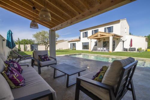 d'une terrasse avec des chaises et une table à côté de la piscine. dans l'établissement Maison Tivollier, à Maillane