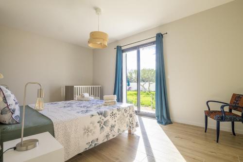 une chambre avec un lit et une fenêtre avec des rideaux bleus dans l'établissement Maison Tivollier, à Maillane