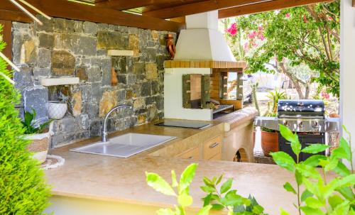 a kitchen with a sink and a stone wall at Bali Bay Villa in Bali