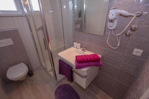 a bathroom with a toilet and a sink and a shower at Villa Stella in Rogoznica