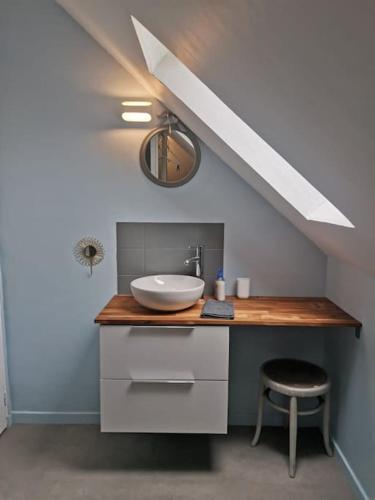La salle de bains est pourvue d'un lavabo et d'un comptoir avec un tabouret. dans l'établissement Happiness la maison du bien-être (100 m2), à Béhencourt