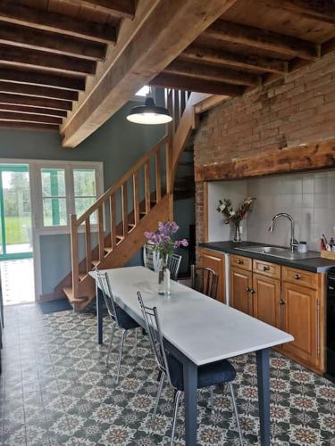 - une cuisine avec une table, des chaises et un évier dans l'établissement Happiness la maison du bien-être (100 m2), à Béhencourt