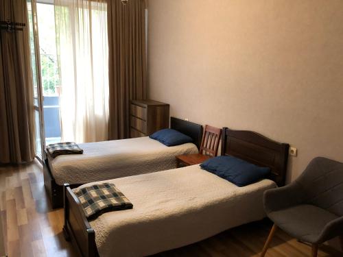a hotel room with three beds and a chair at Cozy apartment in the city center in Tbilisi City