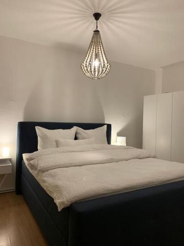 a bedroom with a large bed with a chandelier at Redlinburg II in Quedlinburg