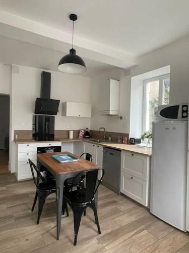 une cuisine avec une table et quelques chaises dans l'établissement Agréable gîte au coeur du centre ville 4 personnes, à Chagny