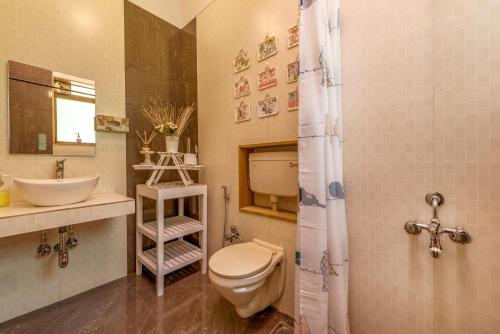 a bathroom with a toilet and a sink at SaffronStays Shambhala Lakeside-Infinity Pool Villa in Pawna in Malavli