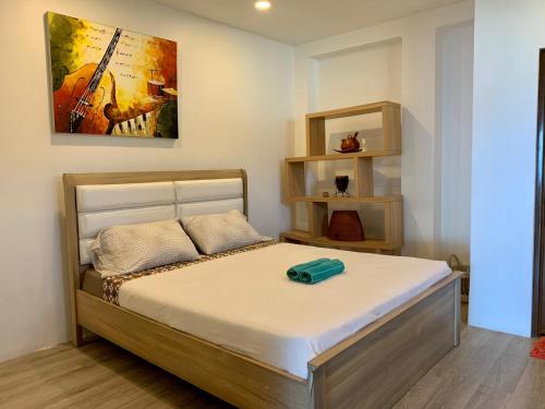 sypialnia z łóżkiem z obrazem gitarowym na ścianie w obiekcie Castaway Surf Retreat 1 w mieście Sekongkang