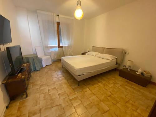 1 dormitorio con 1 cama y TV de pantalla plana en House Cooper - 2 Min Dal Mare, en Marina di Carrara