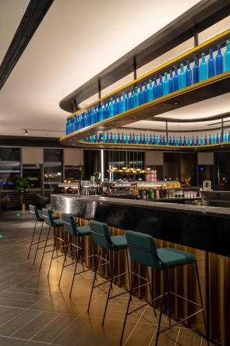 a bar with blue bottles on the counter in a restaurant at CitiGO Hotel Shenzhen Shekou Cruise Center Seaview Near Taizi Bay K11 in Shenzhen