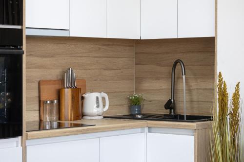 a kitchen with white cabinets and a sink at Salt&Soul Residence in Povljana