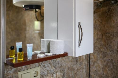 a bathroom counter with toilet paper and cosmetics on it at Apartments 37B in Batumi