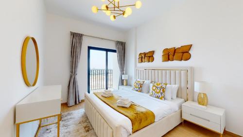 a bedroom with a large bed and a window at Primestay - 3BR in Wasl Gate, close to Metro Station in Dubai