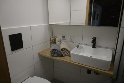 a white bathroom with a sink and a toilet at Kawalerka z antresolą do wzięcia in Gdańsk