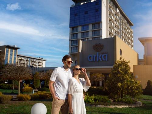 a man and a woman standing in front of a building at Arka Medical Spa in Kołobrzeg