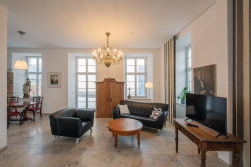 a living room with couches and a television and a table at Sonnenschloss in Walbeck