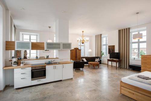 a kitchen with white cabinets and a living room at Sonnenschloss in Walbeck