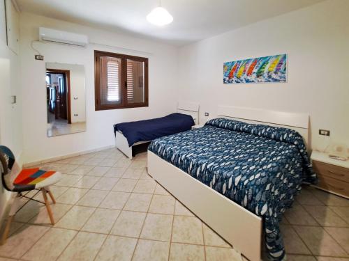 1 dormitorio con 1 cama y 1 silla en Appartamento Trilocale vicino al centro di San Teodoro, en San Teodoro