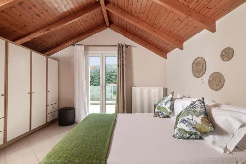 a bedroom with a white bed with a green blanket at Gala's Elegant Home Villa in Zakynthos Town