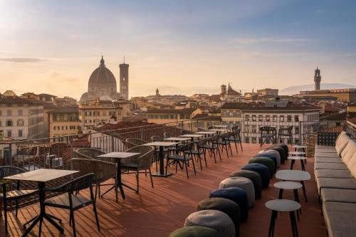 une rangée de tables et de chaises sur le toit d'un bâtiment dans l'établissement Hotel Croce Di Malta, à Florence