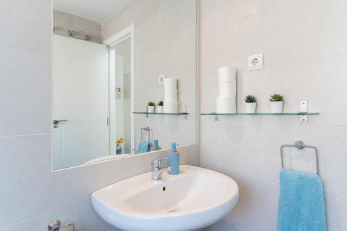 Un baño blanco con lavabo y espejo. en MONKÓ BONAIRE, en Torremolinos
