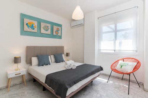 Un dormitorio con una cama y una silla roja. en MONKÓ BONAIRE, en Torremolinos