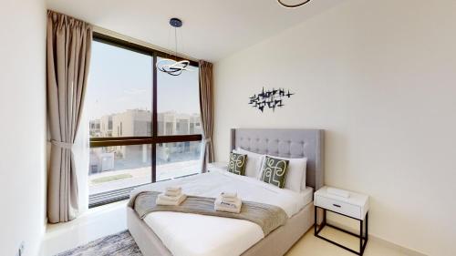 a bedroom with a bed and a large window at Primestay - Odora 6BR, Akoya Oxygen in Dubai