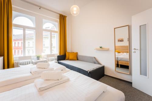 a room with two beds and a couch and a mirror at Self-service Hotel Ostaš Praha in Prague