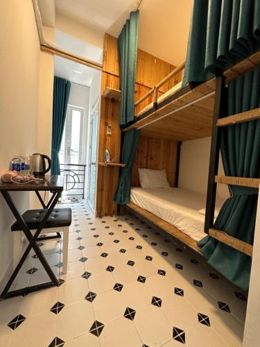 a room with bunk beds with a desk and a table at Vika Homestay in Ho Chi Minh City