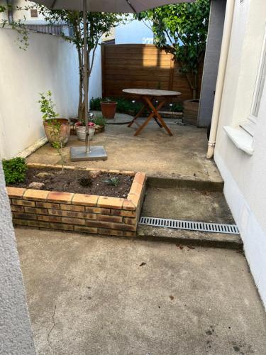 a patio with a picnic table and a table with an umbrella at Le Mans Kleber in Le Mans