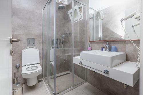 a bathroom with a toilet and a sink and a shower at AÇELYA OTEL in Bodrum City