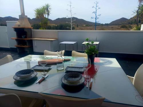 una mesa con platos y copas de vino en el balcón en Casa La Pita, en El Pozo de los Frailes