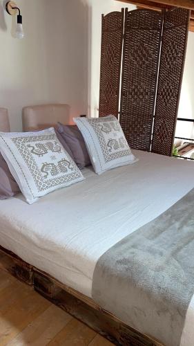 a large bed with white pillows on it at La Casetta in San Nicolò dʼArcidano