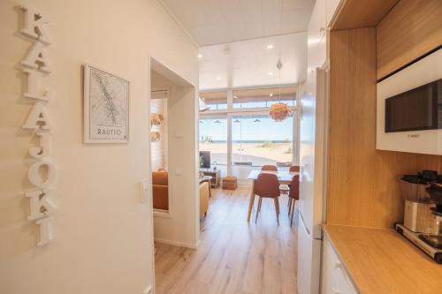 uma cozinha e sala de jantar com vista para o oceano em Apartment Aurinkoranta D5 saunallinen kaksio merinäkymällä Kalajoki em Kalajoki