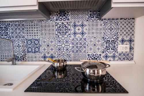 a kitchen with blue and white tiles on the wall at Sea View Luxury Apartment in Castellammare di Stabia