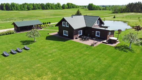 an aerial view of a house on a green field at Sodyba Puodžių Kaimas in Mackėnai
