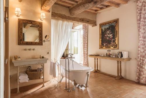 a bathroom with a tub and a sink at Dimora Santa Margherita - Boutique Hotel in Cinigiano