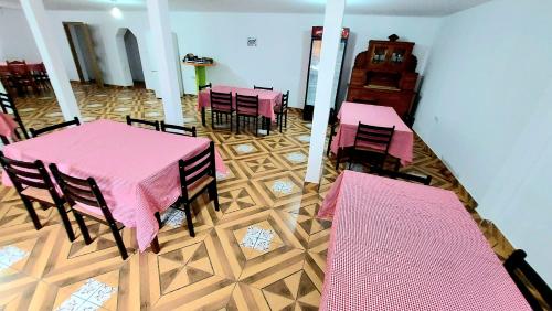 a dining room with pink tables and chairs at PENSIUNEA BOCA VORONET in Voronet