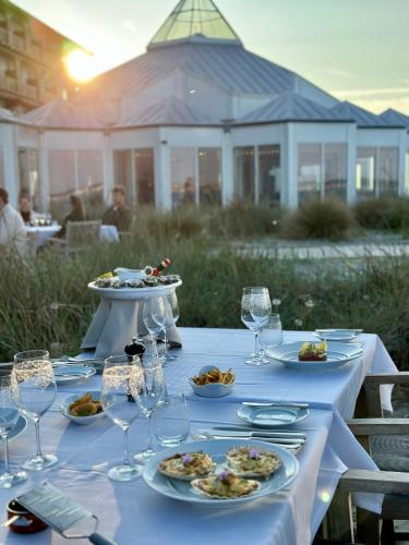 a table with plates of food and wine glasses at Marienlyst Strandhotel in Helsingør