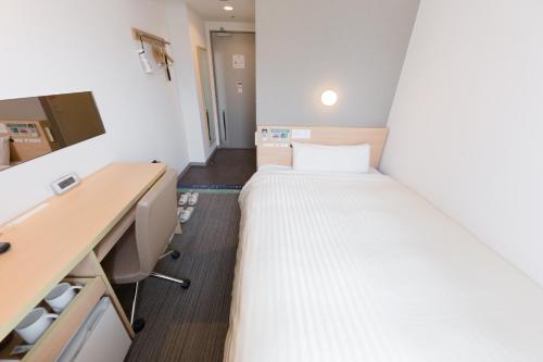 a small room with a bed and a desk at Super Hotel Tokyo Otsuka in Tokyo