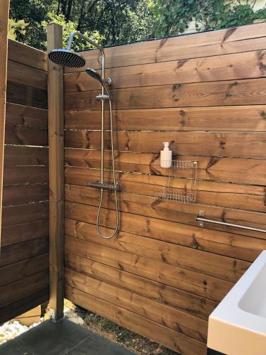 La salle de bains est pourvue d'une douche et d'un mur en bois. dans l'établissement Villa Bonheur Vallespir, à Céret