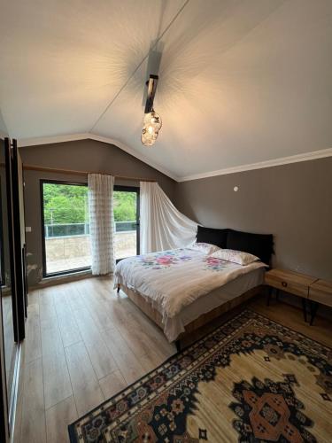 sypialnia z łóżkiem i dużym oknem w obiekcie alsaleh mersin villa w mieście Trabzon