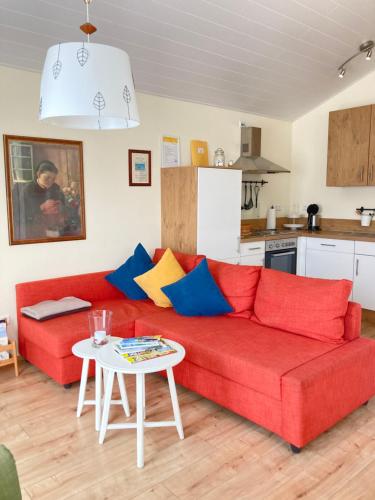 ein Wohnzimmer mit einem roten Sofa und einem Tisch in der Unterkunft Alte Heimat in Schwegenheim