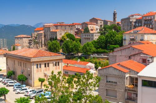 une ville avec des voitures garées dans un parking dans l'établissement Camping Olva - Maeva, à Sartène